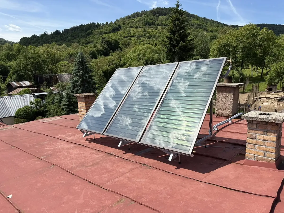 Tri solárne kolektory na nosnej konštrukcii na plochej streche rodinného domu v Silickej Jablonici